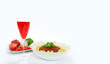 Lampka czerwonego wina i makaron spagetti z sosem neapolitańskim na białym tle.