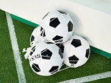 Fototapeta Sport - Classic soccer balls in grid on green football field lawn