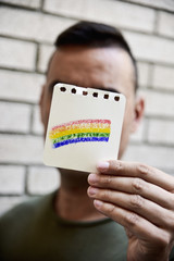 Poster - man with a rainbow flag in a piece of paper