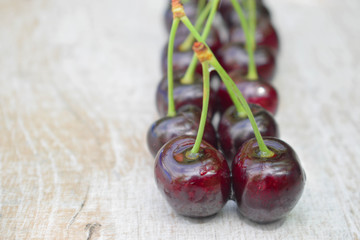 Spelled cherries on the white wooden background