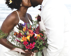 Couple kissing and holding bouquet