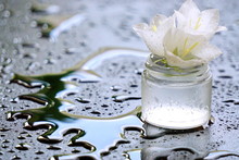 Spa Jar With Lily With Water Drops On Black Background