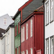 Colored facades, traditional wooden Norwegian houses. Clared-colored, green, white houses.