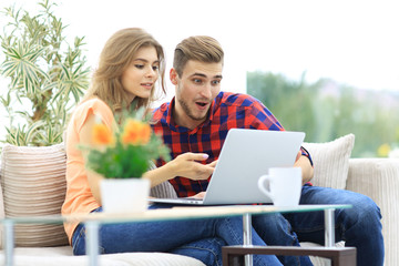 Wall Mural - young woman showing important information to her boyfriend on the laptop screen