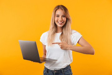 portrait of a smiling young blonde girl holding laptop