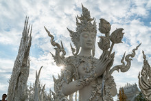 Magnificently White Buddhism Goddess Statue On Blue Sky Clouds With Sun Ray In Rong Khun Temple, Chiang Rai Province, Northern Thailand.