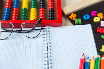 colorful abacus , pencils, clock, chalkboard on the wooden background. Education, back to school concept  