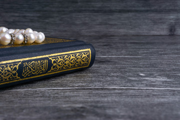 Poster - Kuala Lumpur, Malaysia- December 4, 2017: Closeup of Holy Quran/Koran with beads or Tasbih/Rosary over wooden background.Selective focus and crop fragment.