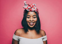 Portrait Of Smiling Woman Wearing Head Tie Over Pink Background