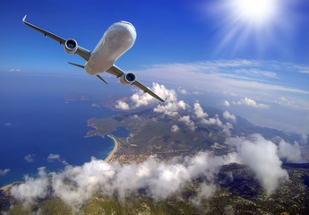 Passenger airplane in the clouds. Aerial view of airplane and Blue Lagoon in Oludeniz