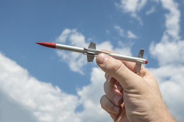 Wall Mural - the person's hand holds a rocket aimed at the sky. missile Warhead, weapons of mass destruction, nuclear bomb, chemical. antimissile defense