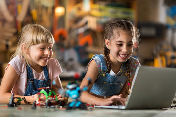 Small girls building toy construction machine
