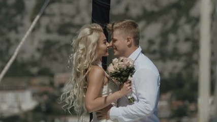 Wall Mural - Beautiful wedding couple spending romantic sunny day onto luxury wooden yacht sailboat in the Adriatic Sea in Montenegro POV. Slow motion
