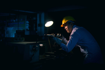 Asian engineer man wearing safety helmet checking and using an equipment in the laboratory. concept of manufacturing mechanical workshop measurement and tools.