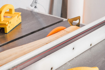 Poster - Cutting the board on a circular saw in a woodworking workshop