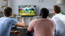 Male Friends Gather To Watch Football Competition On Big Screen, Sofa Experts