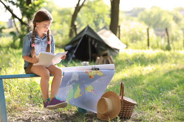 Wall Mural - little girl with map and book near tent outdoors. summer camp