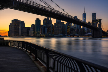 Fototapete - Lower Manhattan skyscrapers and the Brooklyn Bridge at sunset from Empire Fulton Ferry Park (Brooklyn). Manhattan, New York City