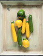 Fresh yellow and green zucchini from the market in a vintage tray background 