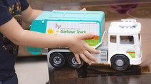 Little Boy Holds With His Hands A Garbage Truck Toy 