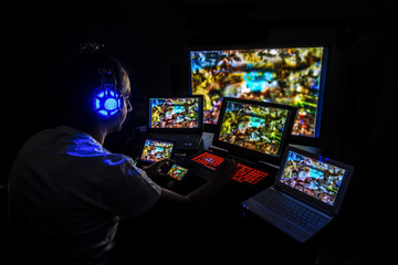 Young gamer playing video game wearing headphone.