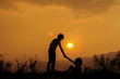 © AungMyo - silhouette of little girl helping sister at sunset time,