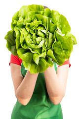 Wall Mural - Female supermarket or grocery employee covering face with lettuce.