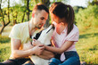 © galina_kovalenko - Lifestyle, happy family of two resting at a picnic in the park with a dog.