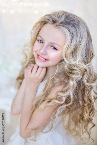 Beautiful Little Girl With Long Blonde Hair Poses In The Studio