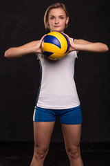 Wall Mural - Girl playing volleyball on a dark background