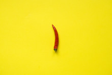 Red chili pepper pods on bright yellow background