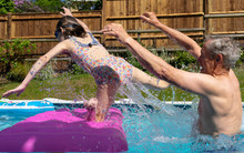 Grandfather Throwing Granddaughter In Swimming Poo