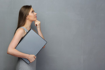 Poster - Profile portrait of thinking woman holding laptop.