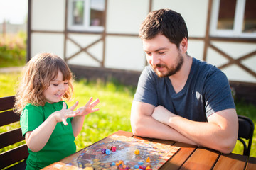 Moscow, june 18 2018. Father and his cute little girl playing strategy board game