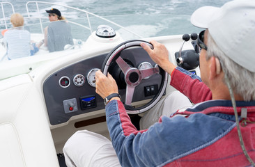 man driving a motor cruiser on the sea