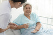 caregiver nurse helping elderly woman taking medicine on the bed and check up after admit inpatient in hospital.