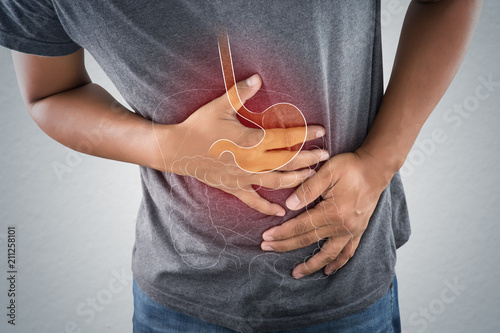 Fotografía Acid reflux or Heartburn, The photo of stomach is on the men's body against gray