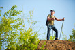 © snedorez - Photo of tourist man with sticks for walking on hill