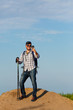 © snedorez - Photo of tourist man in sunglasses photographing phone with sticks for walking on hill