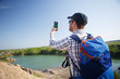 © snedorez - Image of tourist with backpack photographing on hill