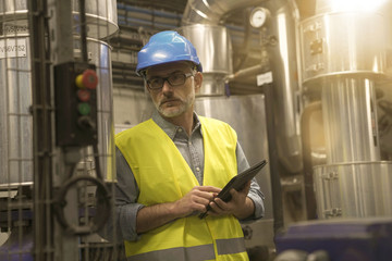 Wall Mural - Industrial technician connected with tablet in recyling plant