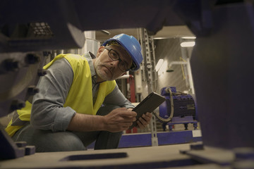 Wall Mural - Industrial technician connected with tablet in recyling plant