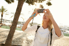 A Girl Taking A Photo With A Little Camera In Barcelona In Front Of Palms