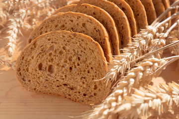 Bread with grain on wooden background.