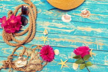 Wall Mural - Summer vacation concept of ropes, sunglasses and pink blossoms on blue wooden background