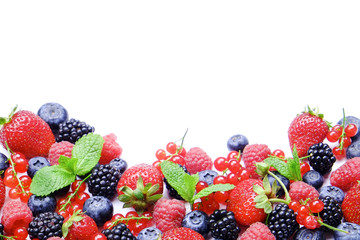 Bunch of mixed berries in harvest pile on white background. Colorful composition with fresh organic strawberry, blueberry, blackberry & redcurrant. Clean eating concept. Close up, copy space, top view