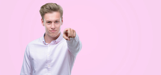 Sticker - Young handsome blond man pointing with finger to the camera and to you, hand sign, positive and confident gesture from the front