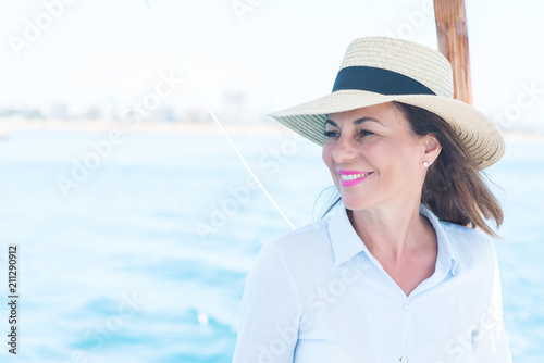 Beautiful middle age woman traveling on sailboat and smiling happy and confident Tableau sur Toile