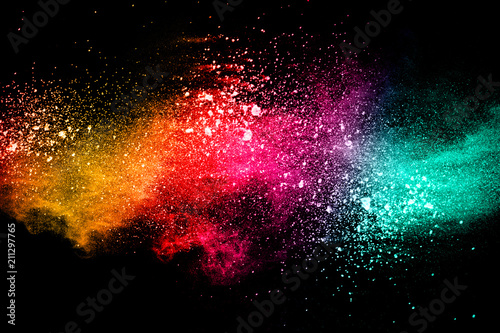 Abstract multi color powder explosion on black background.  Freeze motion of ...