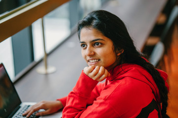 Closeup of young attractive Indian lady thoughtfully looking away 